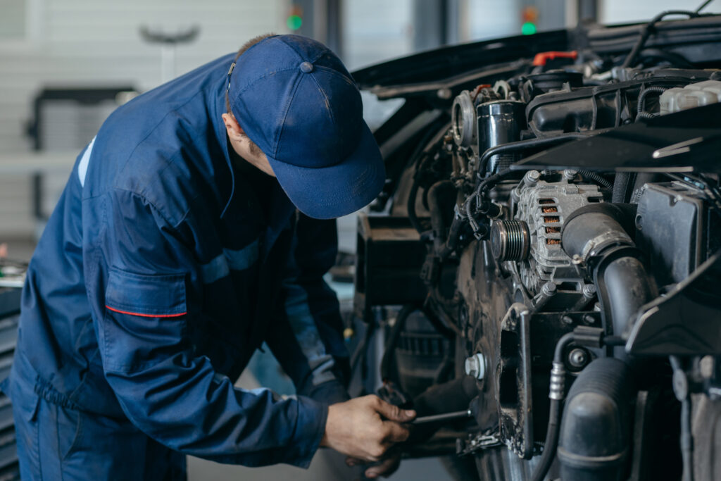 Mobile diesel mechanic performing engine maintenance on a commercial vehicle.